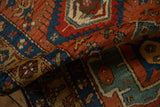 A folded corner of an antique Heriz rug showing the dense wool pile and geometric designs.