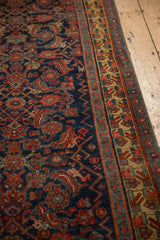 Geometric finned floral border in saffron yellow beside the cobalt blue Herati field of an antique Bijar.