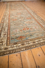 Distressed Malayer runner close-up with copper serrated diamonds, teal field, and animal motifs.