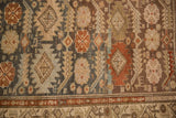 Distressed vintage Malayer runner close-up featuring terracotta vine border and geometric field in teal, beige.