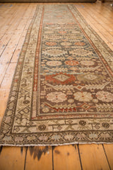 Serrated terracotta diamonds, dusty teal, and animal figures on a distressed Malayer runner.