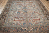 Textured field of a distressed Heriz carpet with muted floral vines and border.