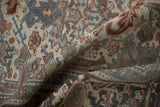 Vintage distressed Heriz rug's worn pile, revealing muted ivory, denim blue, and chestnut colors.