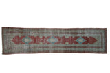 Antique distressed Serbend runner with a raspberry red field and a central row of blue diamond medallions.
