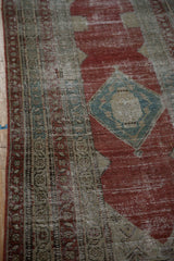 Distressed pile of an antique Serbend runner showing the blue diamond medallion and rhythmic floral border.