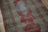 Low pile texture of a distressed Serbend runner with a raspberry red field and blue medallion.