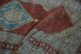 Softly draped antique Serbend runner showing the texture of worn pile on its red and blue motifs.