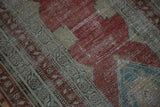 Close-up view of heavy wear on an antique Serbend runner, revealing the textured knot heads.