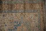 Distressed Karaja runner corner showing geometric borders in brown, ivory, and blue tones.