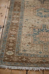 Close-up of vintage Karaja runner end, showing ivory fringe and distressed brown-blue border.