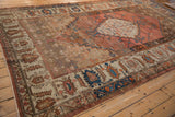 Storied texture and low pile on an antique Bakshaish carpet shown from a full-length angle.