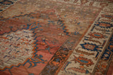 Angled view of an antique Bakshaish carpet showing the low pile, stepped patterns, and abrashed ground.