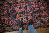 Textured low pile of a vintage Persian rug with sapphire blue and brown floral vines.