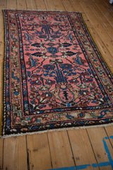 Angled view of a vintage Persian rug showing its textured pile and traditional floral design.