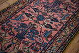 Angled perspective of germinating blossoms and floral vines on a dusty rose Persian rug.