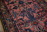 Close-up of the vintage Mehriban rug's low pile showing colorful petaled flowers and vines.