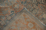 Distressed vintage Bijar rug corner with dusty blue, terracotta Herati pattern and machine-bound side.