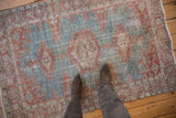 The distressed texture and mostly even wear of a vintage blue and red Persian Veece rug.
