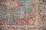 Hand-knotted texture of a distressed Persian rug with wear revealing the ivory foundation.
