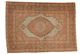 Antique Tabriz rug with a scalloped floral medallion and spandrels in dusty blue, beige, and pink.