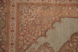 Antique Tabriz rug's corner spandrel showing scalloped floral motifs in sandalwood, pink, and charcoal.