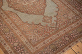 Floral and palm motifs in the border and corner spandrel of an antique Persian Tabriz rug.