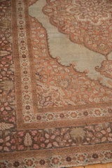 Scalloped spandrel and main border of an antique Tabriz with intricate floral and palm motifs.
