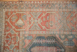 Distressed wear on the cartouche border of a vintage Bakhtiari rug with red and slate blue details.