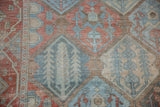 Detail of a vintage Bakhtiari rug's panel design with cypress trees in worn cherry red and dusty blue.