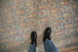 Close-up showing the low pile and terracotta rust boteh design of a distressed Serbend rug.