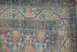 Corner view of the Serbend blossom motif and meandering vine border in rust and pale blue.