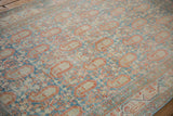 Close view of the staggered boteh pattern and distressed, low-pile texture of a vintage Serbend rug.