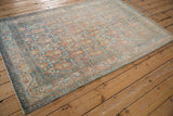 Angled perspective of a vintage distressed Serbend rug with an allover boteh design.
