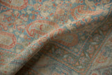 Textured, low pile of a distressed Serbend rug with terracotta and pale blue boteh motifs.