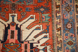 Detail of sharp geometric motifs in red, ivory, and blue on an antique Karaja rug with short pile.