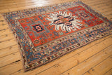 Full angled view of an antique Karaja rug with its bold starburst medallion and geometric borders.