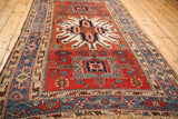 Angled perspective of an antique Karaja rug highlighting its geometric starburst medallion and long profile.
