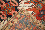 A folded corner of an antique Karaja rug reveals the short pile and hand-knotted foundation.