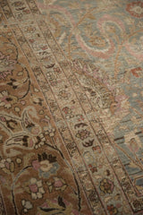 Distressed vintage Meshed rug detail showing intricate small blossoms and a pale ribbon cloud band.