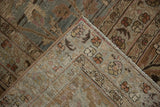 Folded corner of the distressed Meshed rug reveals worn pile, dusty blue, and bound edge.