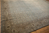 Angled view of a distressed Tabriz carpet with its turtle samovar border and allover Herati field.