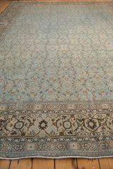 A low perspective showing the large scale Herati border and denim blue field of a vintage Tabriz carpet.