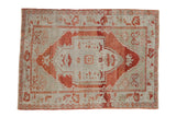 Vintage distressed Oushak rug with a red shield medallion on an abrashed seafoam green field.