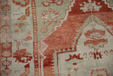 Close-up of the distressed Oushak rug's worn pile and hand-knotted texture.