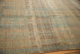 Low-pile texture and heavy color abrashes on a distressed Persian Belouch carpet's surface.