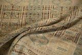Folded view of the distressed Belouch carpet showing the low pile texture and abrashed blue motifs.