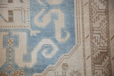 Low-pile texture of a vintage Caucasian rug with a sky blue scrolling cloud-band design.
