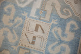 Close-up showing the even wear and geometric patterns of the hand-knotted Caucasian rug in sky blue and beige.