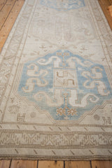 A low angle view down the length of a distressed Caucasian runner with oversized blue medallions.