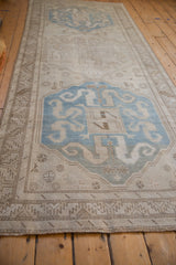 Long view of a vintage Caucasian runner showing repeating blue and platinum geometric medallions.
